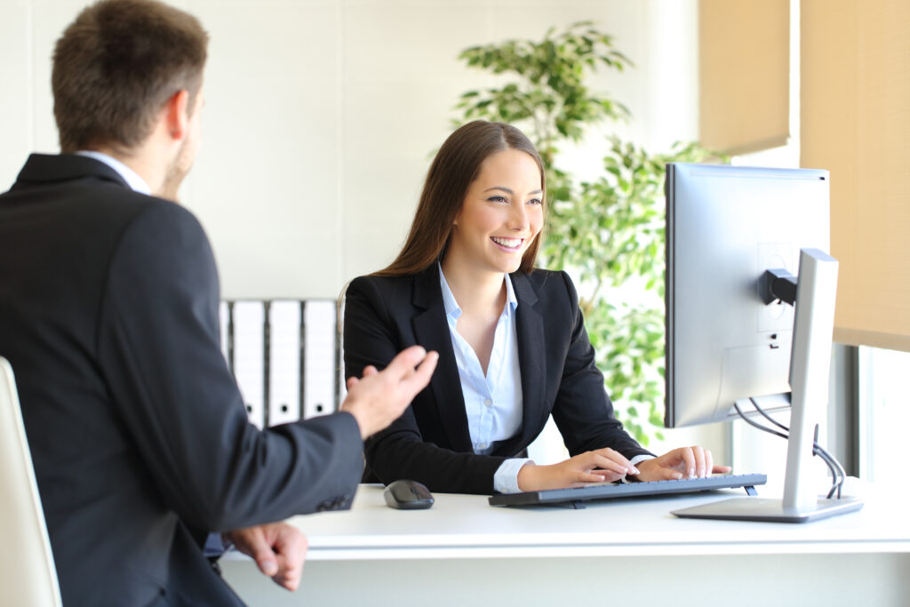 salesperson behind desk with customer