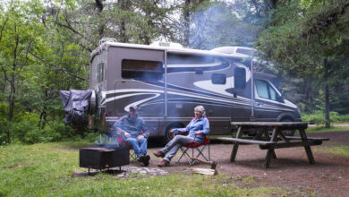 couple relaxing by a fire next to their RV