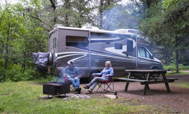 couple relaxing by a fire next to their RV