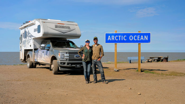 Influencer Marketing Produces Road-Tested Results 4 A man and a woman standing in front of an RV and a sign that says Arctic Ocean.
