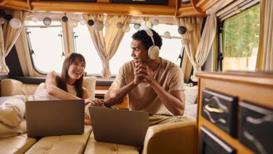 RV Connectivity Trends: What To Know 8 A man and woman sitting in an RV or camper van, with laptops in front of them to demonstrate RV connectivity and Wi-Fi.