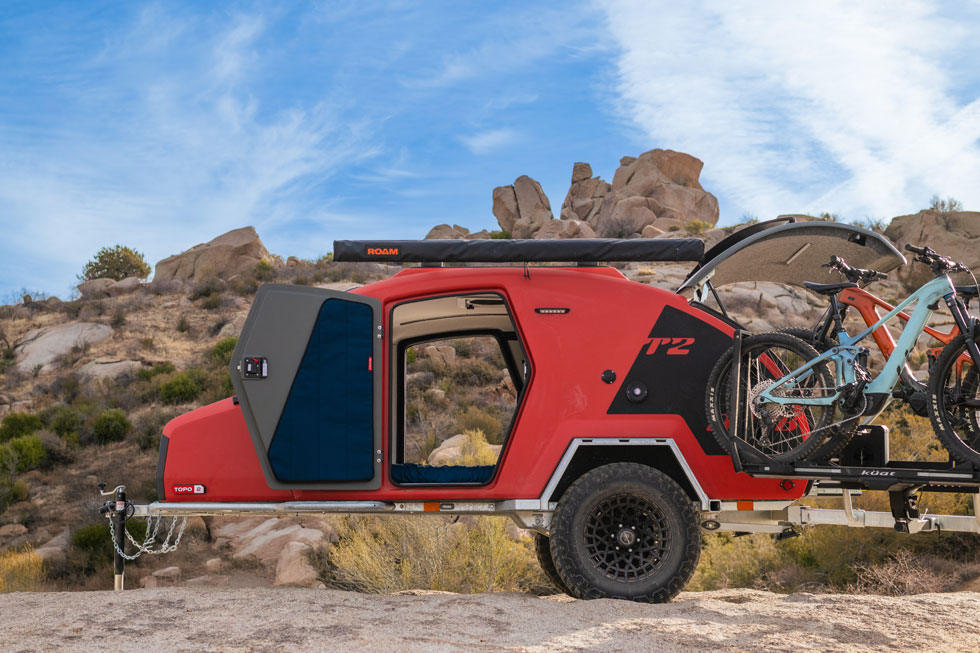 Escapod's TOPO2 MTB teardrop camper with doors open and the back hatch open with bikes stowed.