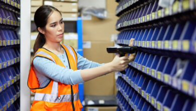 Parts Department Storage Best Practices To Boost Productivity & Sales 7 A woman using laser barcode scanner and looking at parts storage cabinet to demonstrate organizing an RV dealership parts and accessories department.