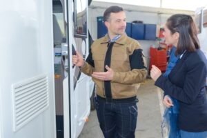 A salesman showing an RV to a female customer.