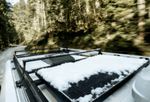 Snow on RV rooftop solar panels to illustrate the importance of solar maintenance.