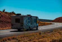 RV on roadway with blue sky above, demonstrating transporting RVs