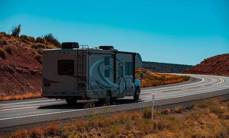 RV on roadway with blue sky above, demonstrating transporting RVs