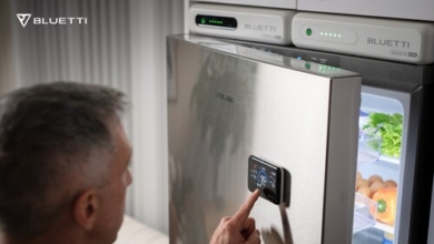 BLUETTI FridgePower Solution seamlessly installed above a home refrigerator, with the FridgePower unit on the left, a BlueCell 200 expansion battery on the right, and the Display 1 magnetic screen attached to the fridge door for instant energy monitoring.