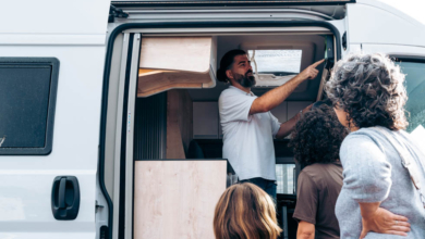 Salesman enthusiastically explaining features of a camper van to a family, who is engaged in the buying process and considering their options, illustrating success in peak season.