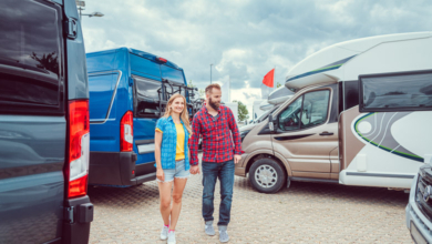 Couple facing abundance of choice in camper vans to buy standing between the vehicles, illustrating how to analyze buyer behavior.