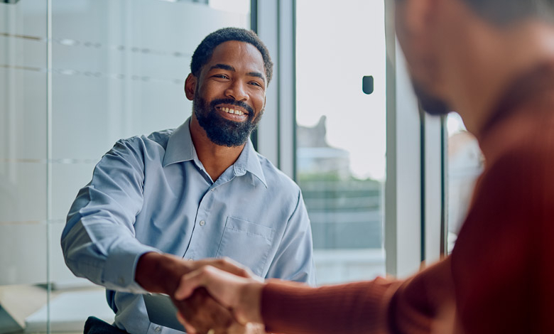 Businessmen shaking hands, illustrating building customer connections and making RV sales.