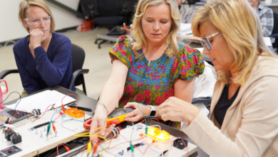 Women sit around a table with wired technical schematics, illustrating women's technical training for the RV industry.