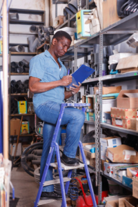 Salesman checking goods availability on shelves of building materials shop
