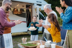 RV Rentals Are for More Than Camping, RVezy Says 2 Multigenerational family celebrating girls birthday in front of an RV